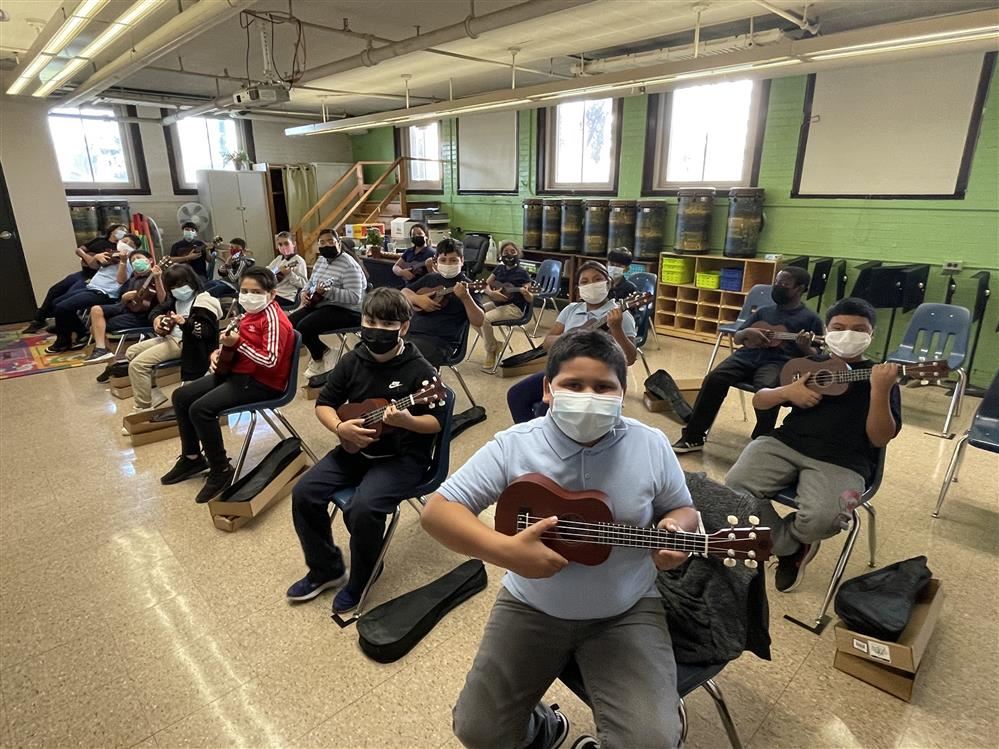  Students playing ukuleles.